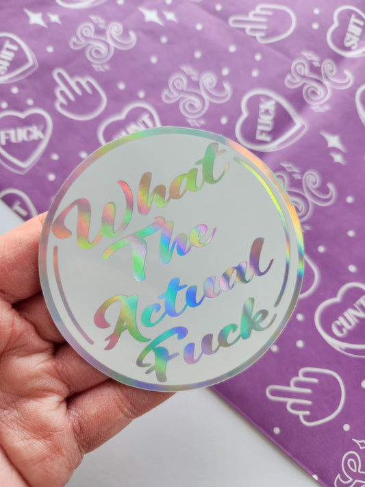 Holographic sticker with text held over a purple background with white patterns
