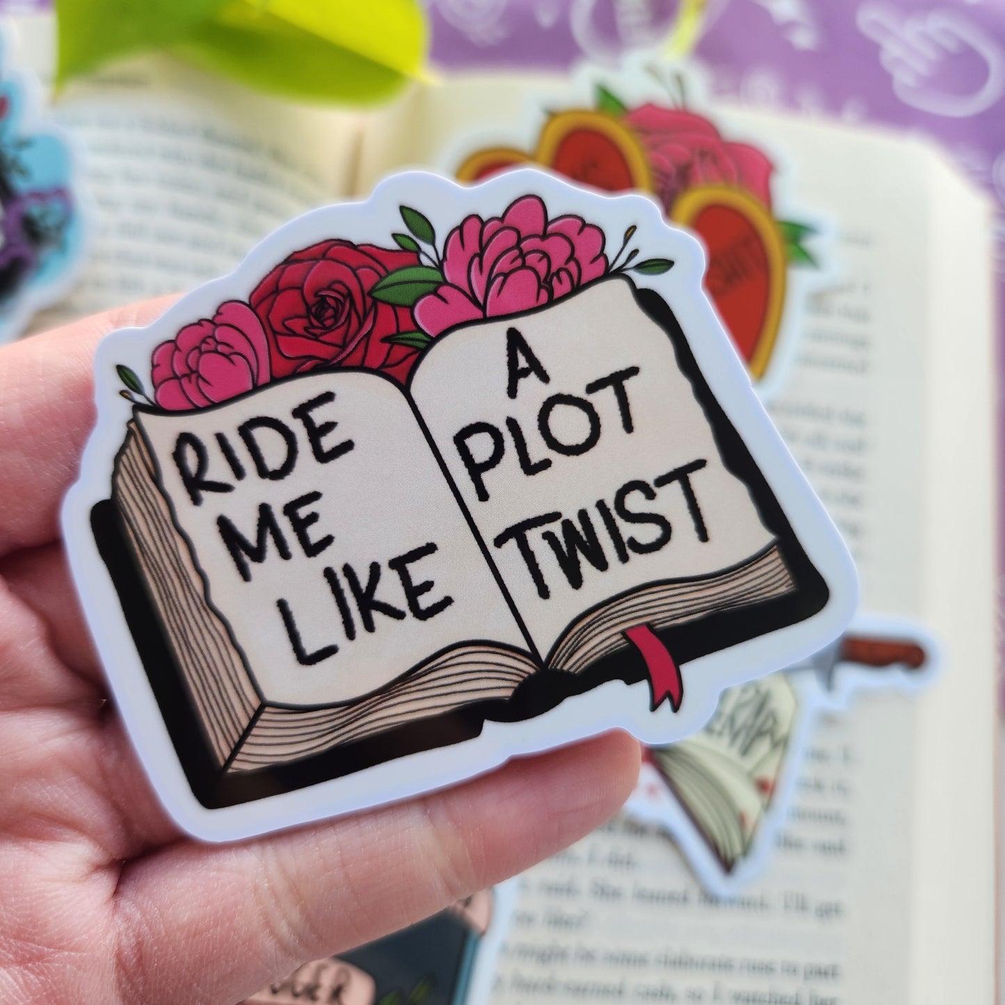 Bookish sassy sticker being held over a book